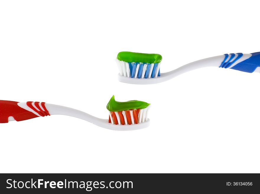 Two toothbrushes with toothpaste on a white background