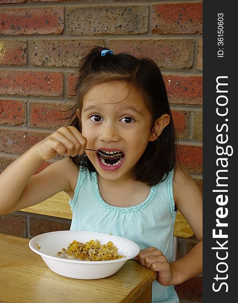 Young Asian Girl Eating Breakfast Cereal.