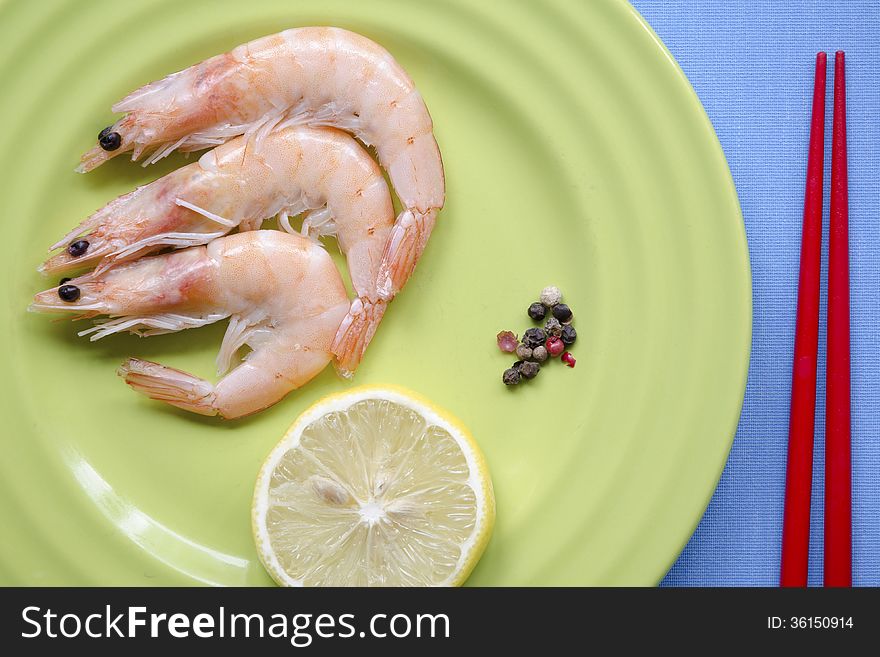 Shrimps portion on green plate with lemon slice. Shrimps portion on green plate with lemon slice