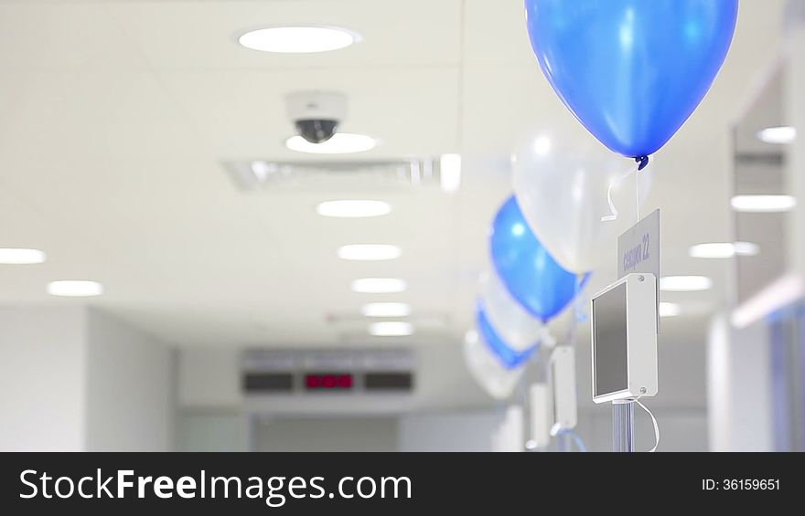 Blue and white balloons swaying on cords in the office. Blue and white balloons swaying on cords in the office