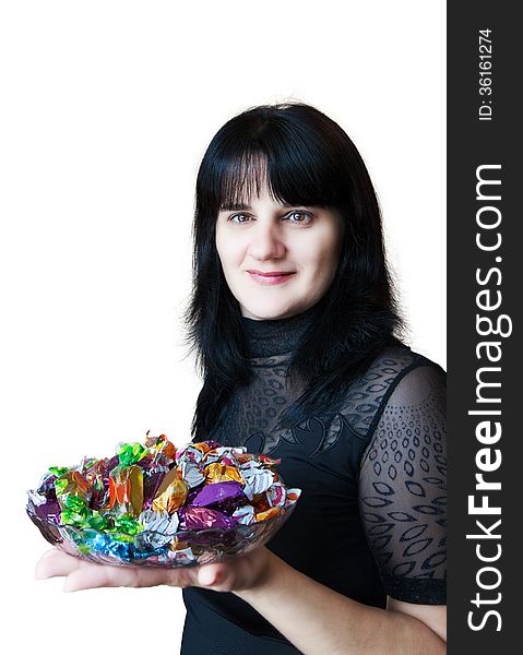 Young beautiful woman in black blouse holding a dish of candy isolated on white background