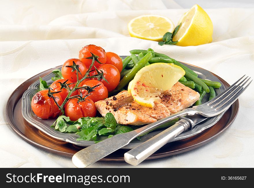 Salmon with green beans and tomatoes on a silver plate