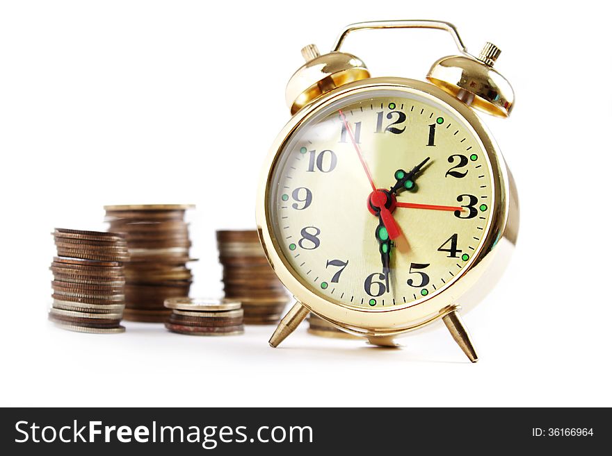 Alarm clock and coins in pile isolated on white, money concept