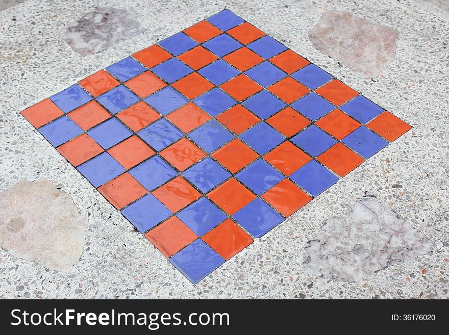 Close up square checkers on a marble table.