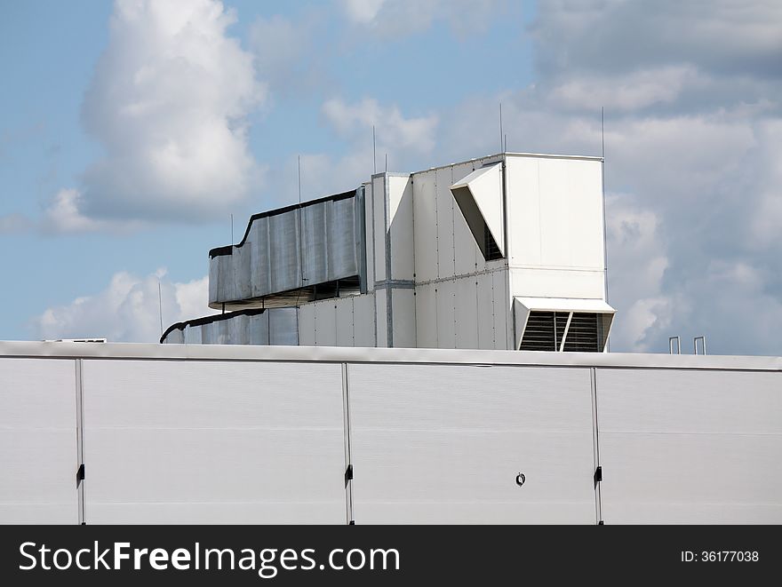 Ventilation pipes and actuators on the roof of an industrial building. Ventilation pipes and actuators on the roof of an industrial building