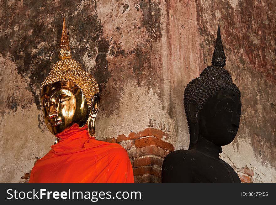 Golden Buddha stute and Black stute in ancient temple of Thailand