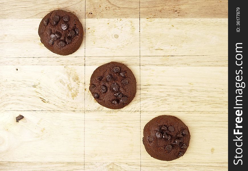 Winner cross line pattern of xo game, play by dark brown cookies on wood background. Winner cross line pattern of xo game, play by dark brown cookies on wood background.