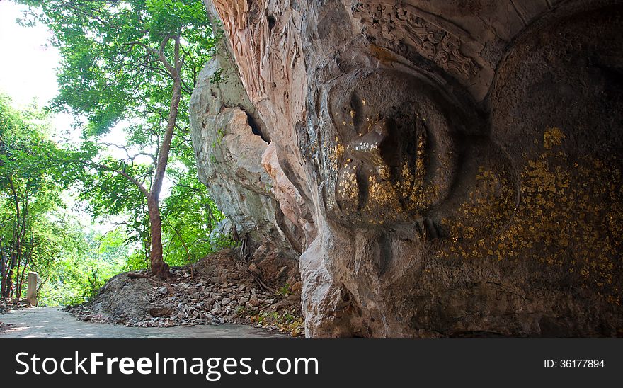 The stucco of ancient reclining Buddha at the Khao Ngu Cave in T