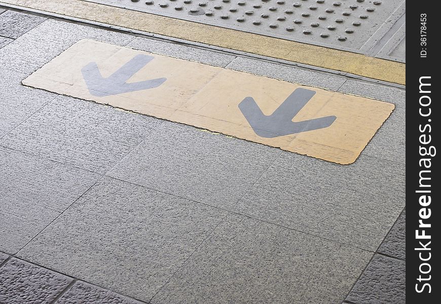 Dual arrow sign on edge sky train platform. Dual arrow sign on edge sky train platform