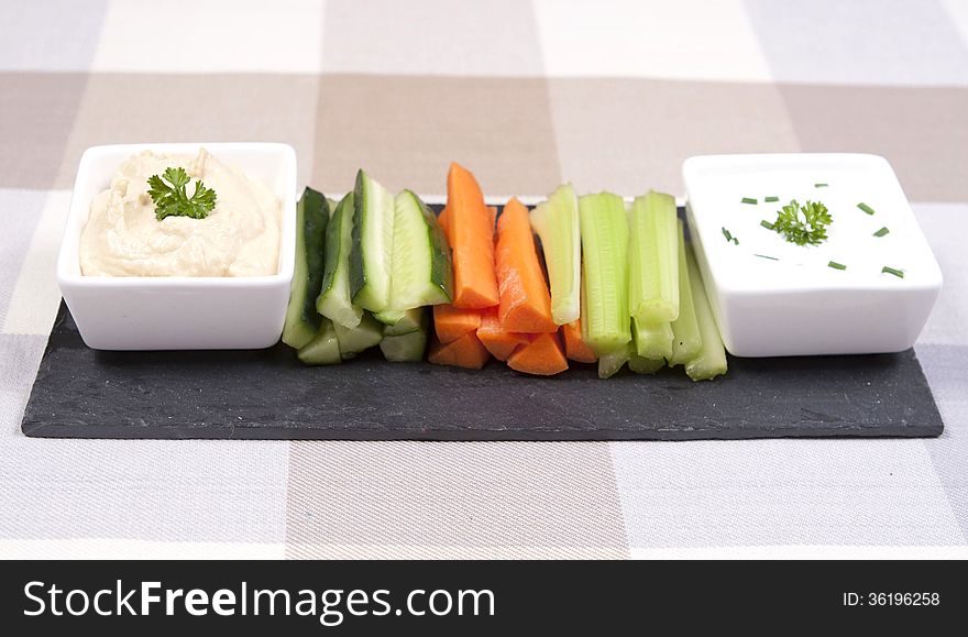 A slate plate of crudités and dips