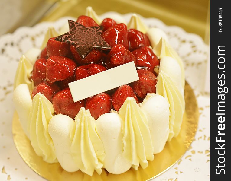 Small little strawberry cheesecake with empty label for advertise. Image taken in a bakery as a closeup.