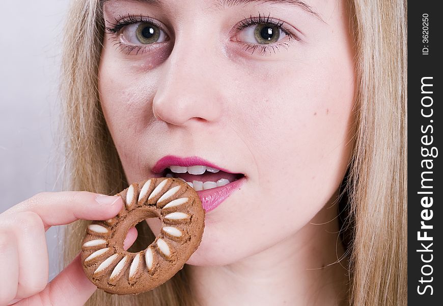 An attractive blonde girl eating cookie