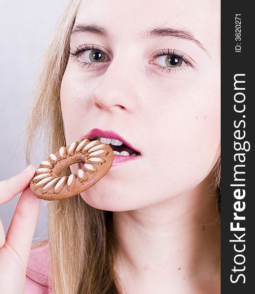 An attractive blonde girl eating cookie