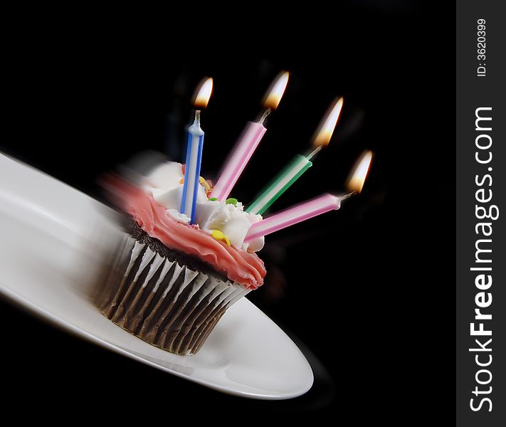 Cupcake starting to fall from a plate. Cupcake starting to fall from a plate.