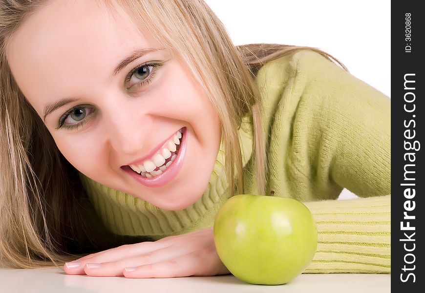Smilling student and green apple on the table
