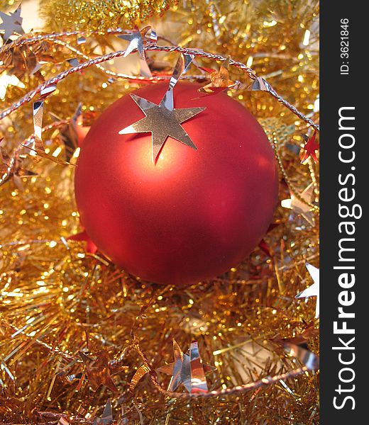 Red christmas ball with golden star on golden glare background
