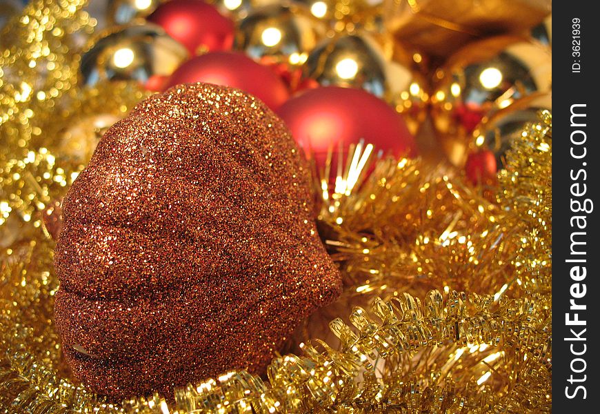 Bronze christmas toy on golden and red balls and glare background