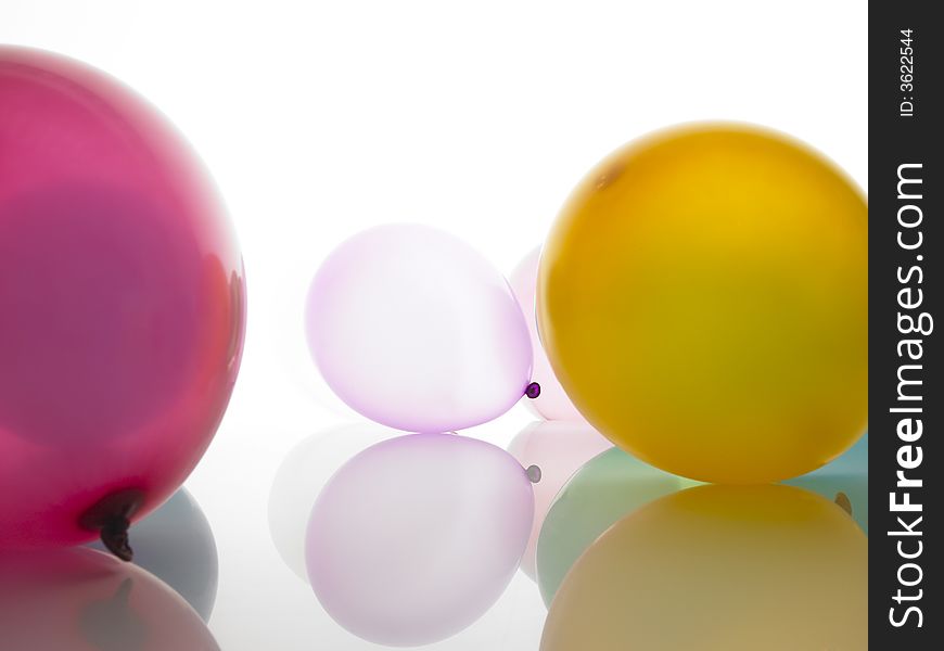 Coloured balloons lying on a white surface.