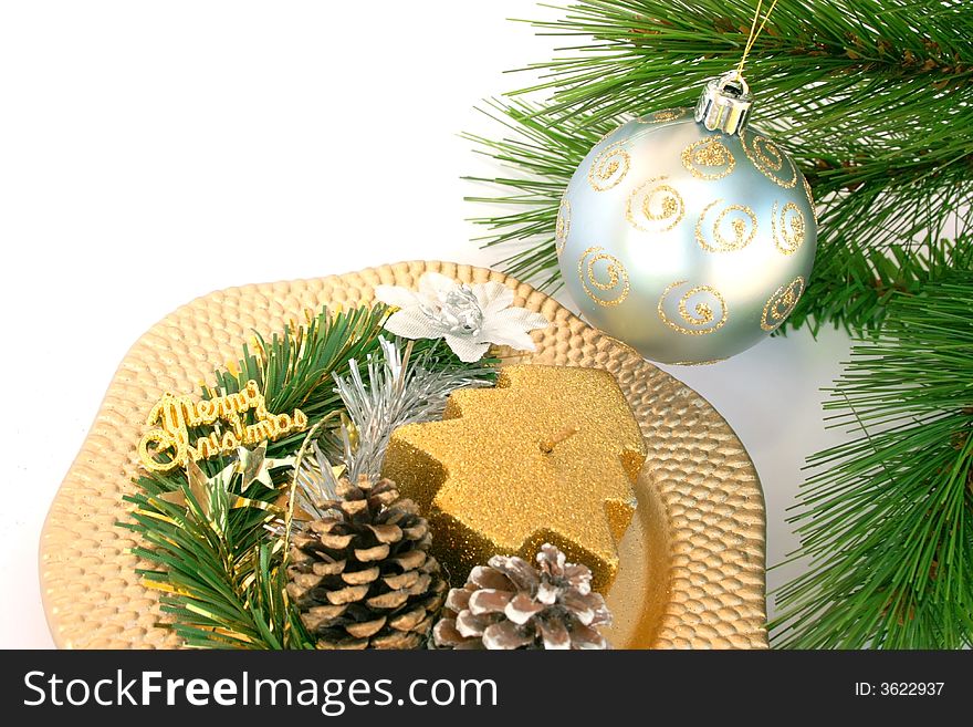 Christmas gray ball on the fir-tree and golden dish with candle,cones,flower.