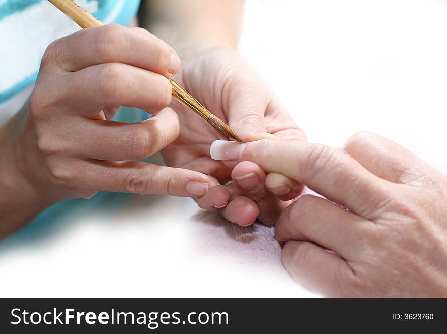 Manicurist treating customer at beauty salon