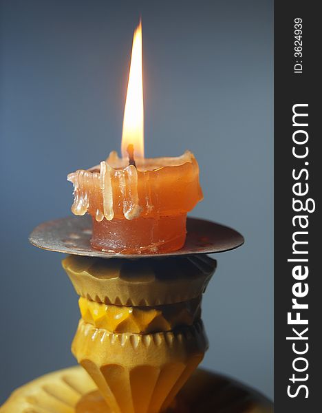 Macro photo of celebration burning candle on a wooden candlestick