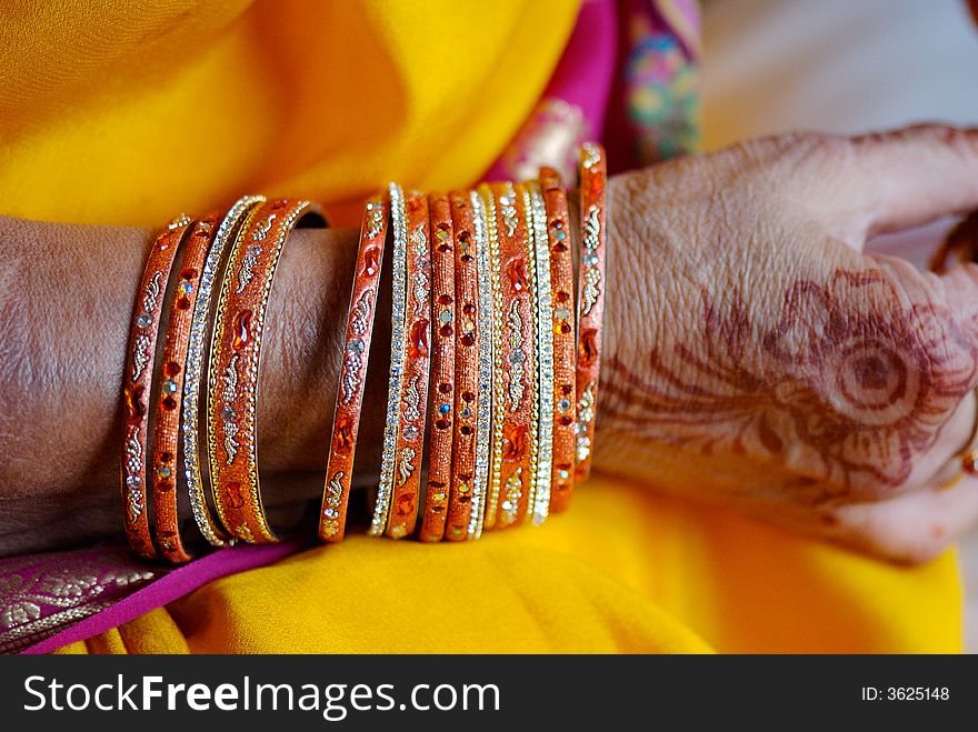 Gold and jeweled bangles on mother of Hindu bride. Gold and jeweled bangles on mother of Hindu bride