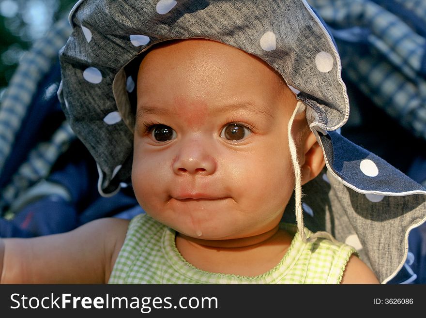 Cute little baby girl in summer outfit wearing a hat, making happy face. Cute little baby girl in summer outfit wearing a hat, making happy face