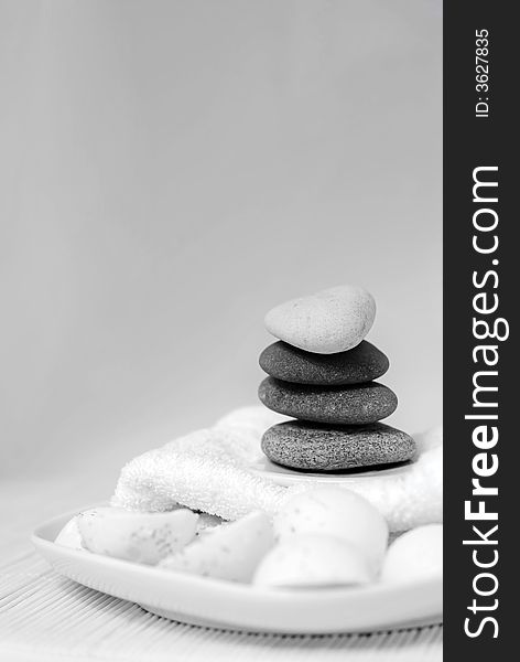 Natural oil soaps with pebble stones and white towel in black and white tones. Natural oil soaps with pebble stones and white towel in black and white tones