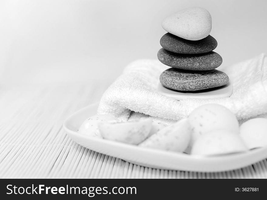 Natural oil soaps with pebble stones and white towel in black and white tones. Natural oil soaps with pebble stones and white towel in black and white tones