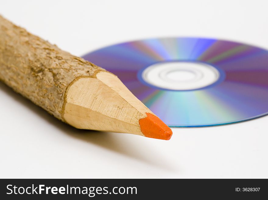 Colored pencil next to a CD. Colored pencil next to a CD