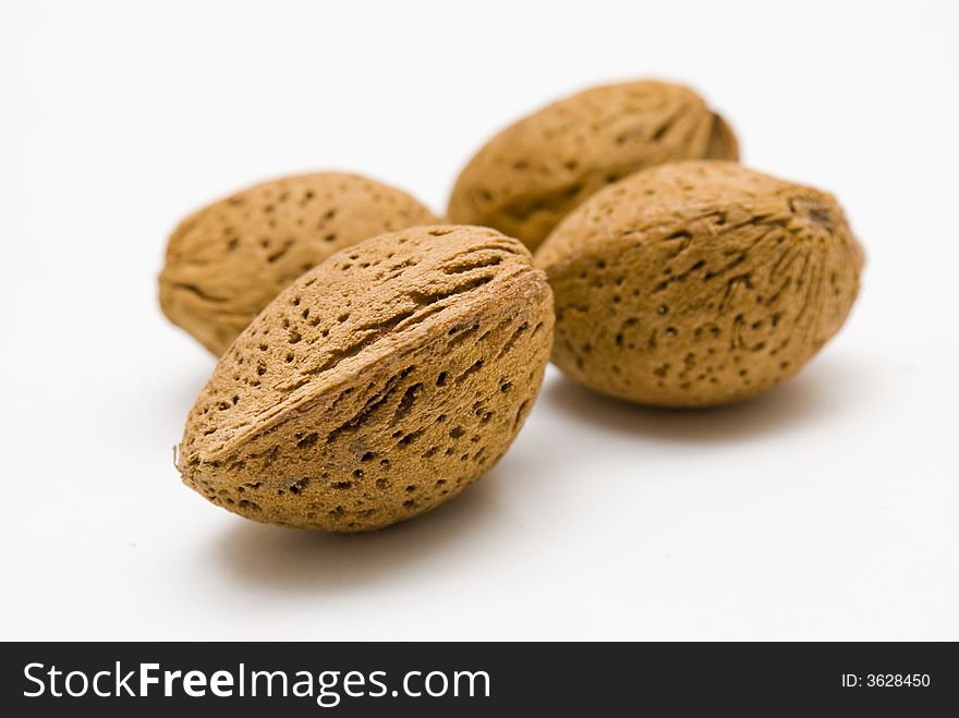 Four almonds on a white table