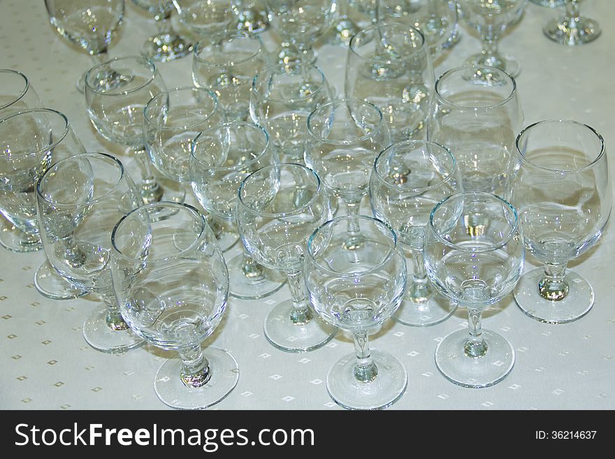 Many empty glasses in a line on table.