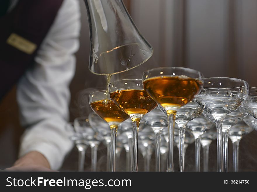 Bartender pours a cocktail at the bar glasses