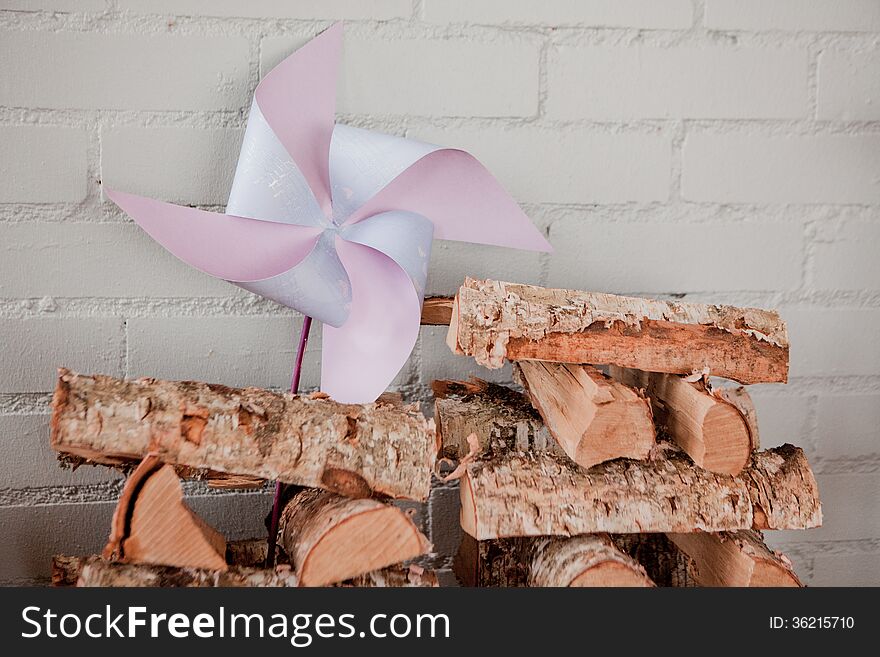 Blue pinwheel with firewood on brickwall