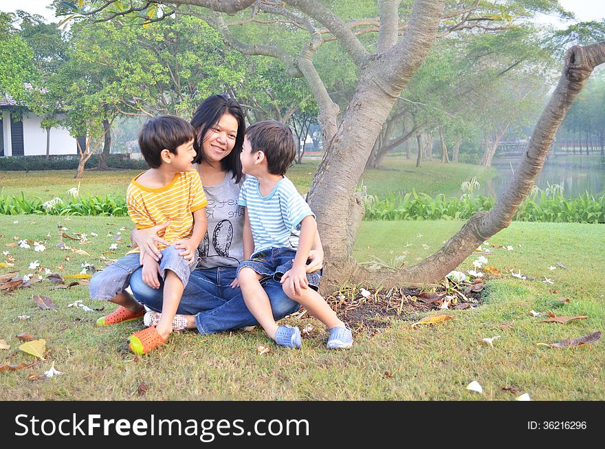 Mother and sons sit together in the park. Mother and sons sit together in the park