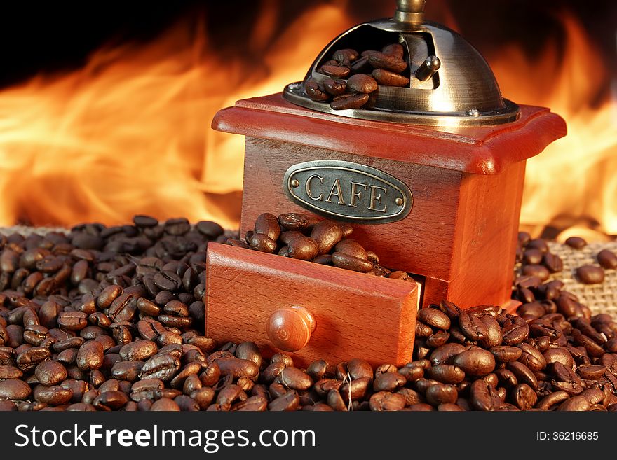 Retro Grinder and Coffee Beans on Burlap at the Fireplace. Retro Grinder and Coffee Beans on Burlap at the Fireplace