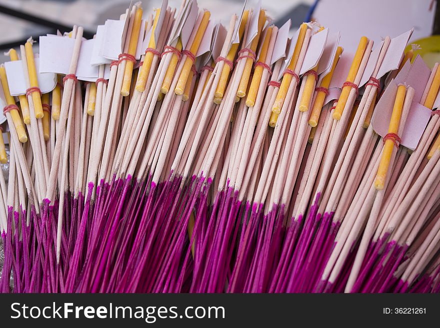 Incense sticks with candle and gold sheet in paper cover