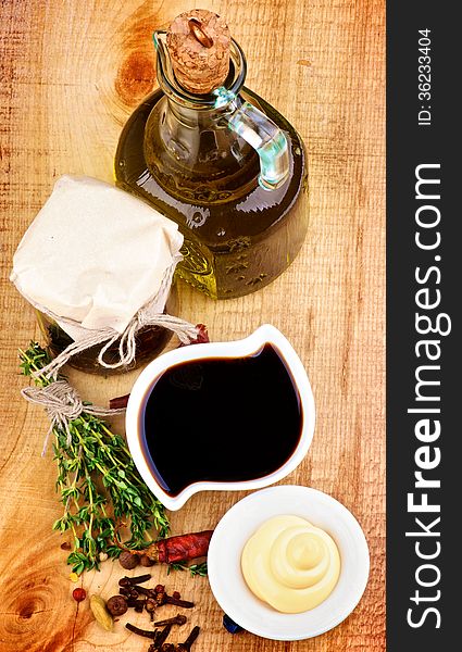 Ingredient for Cooking Salad Sauce with Olive Oil, Spices, Herbs and Mayonnaise closeup on Wooden background. Top View. Ingredient for Cooking Salad Sauce with Olive Oil, Spices, Herbs and Mayonnaise closeup on Wooden background. Top View