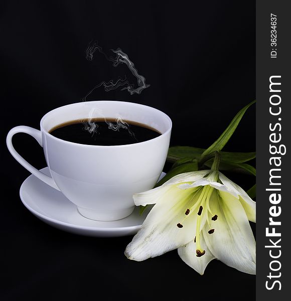 Cup of coffee, steam and white lily on a black background. Cup of coffee, steam and white lily on a black background