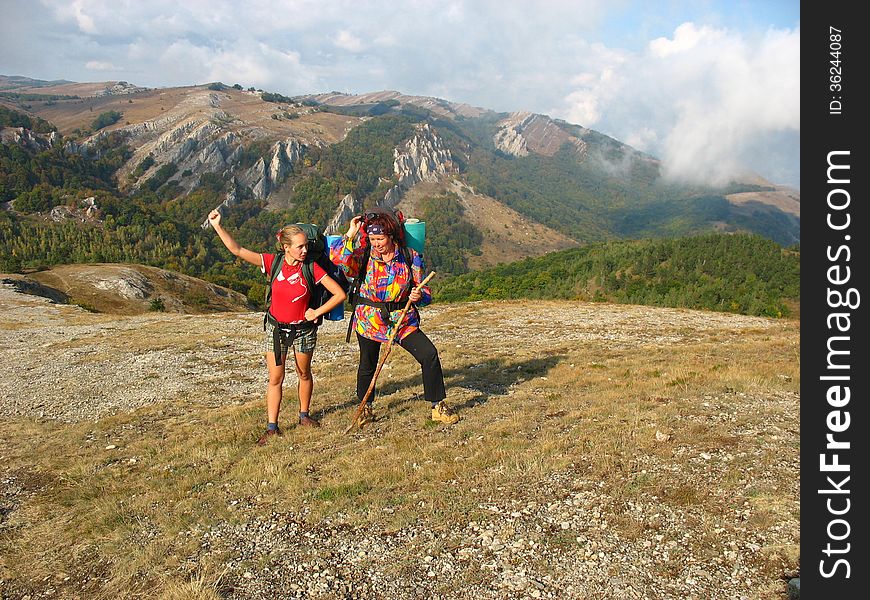 Girls with backpacks posing against the backdrop of the mountains. Girls with backpacks posing against the backdrop of the mountains