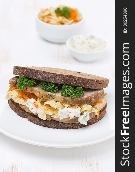 Sandwich of rye bread with coleslaw and meat, vertical