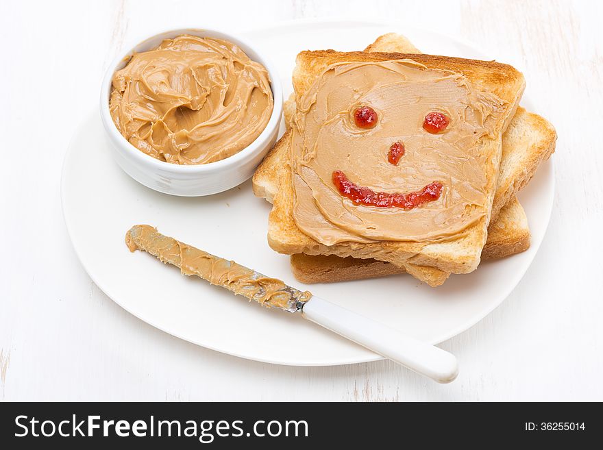 Toast with peanut butter and a painted smile, top view, horizontal