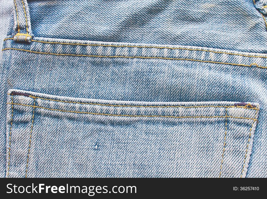 Old blue jeans pocket, close up texture