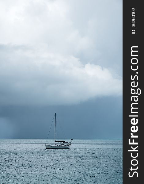 Dark and stormy clouds over the Caribbean ocean, with a sailboat in the foreground 1. Dark and stormy clouds over the Caribbean ocean, with a sailboat in the foreground 1.