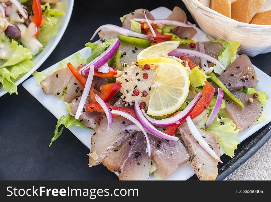 Smoked tuna fish served with baguette and salad. Smoked tuna fish served with baguette and salad.