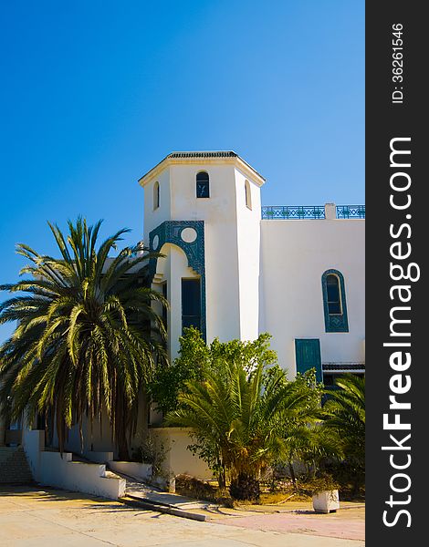 Beautiful white house with palm trees against the sky