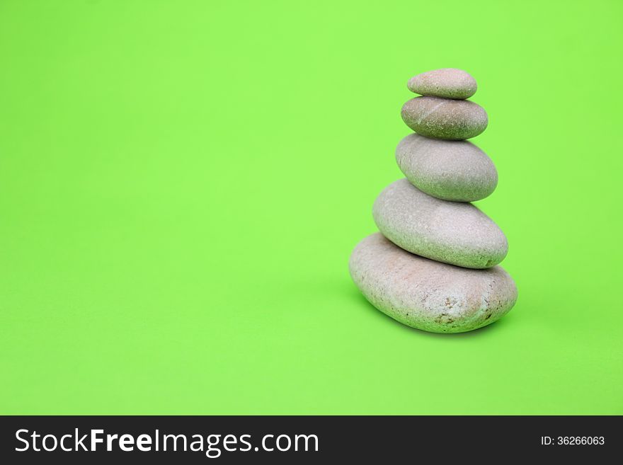 Pyramid of stones on green background