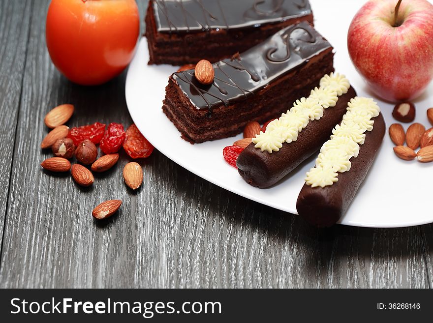 Dessert. Set of chocolate cakes and fruits on white plate. Dessert. Set of chocolate cakes and fruits on white plate