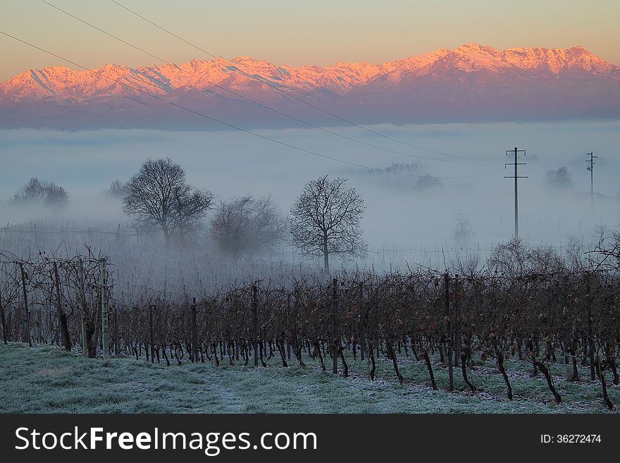 Beautiful winter sunrise on a foggy morning . Alpine mountain of Turin in background . Italy