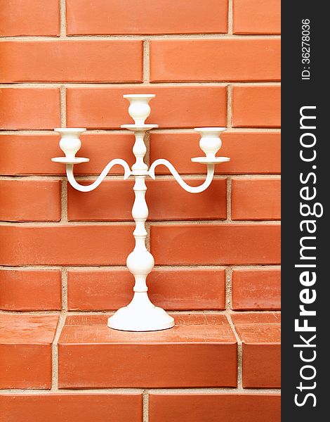 White candlestick on the brick background